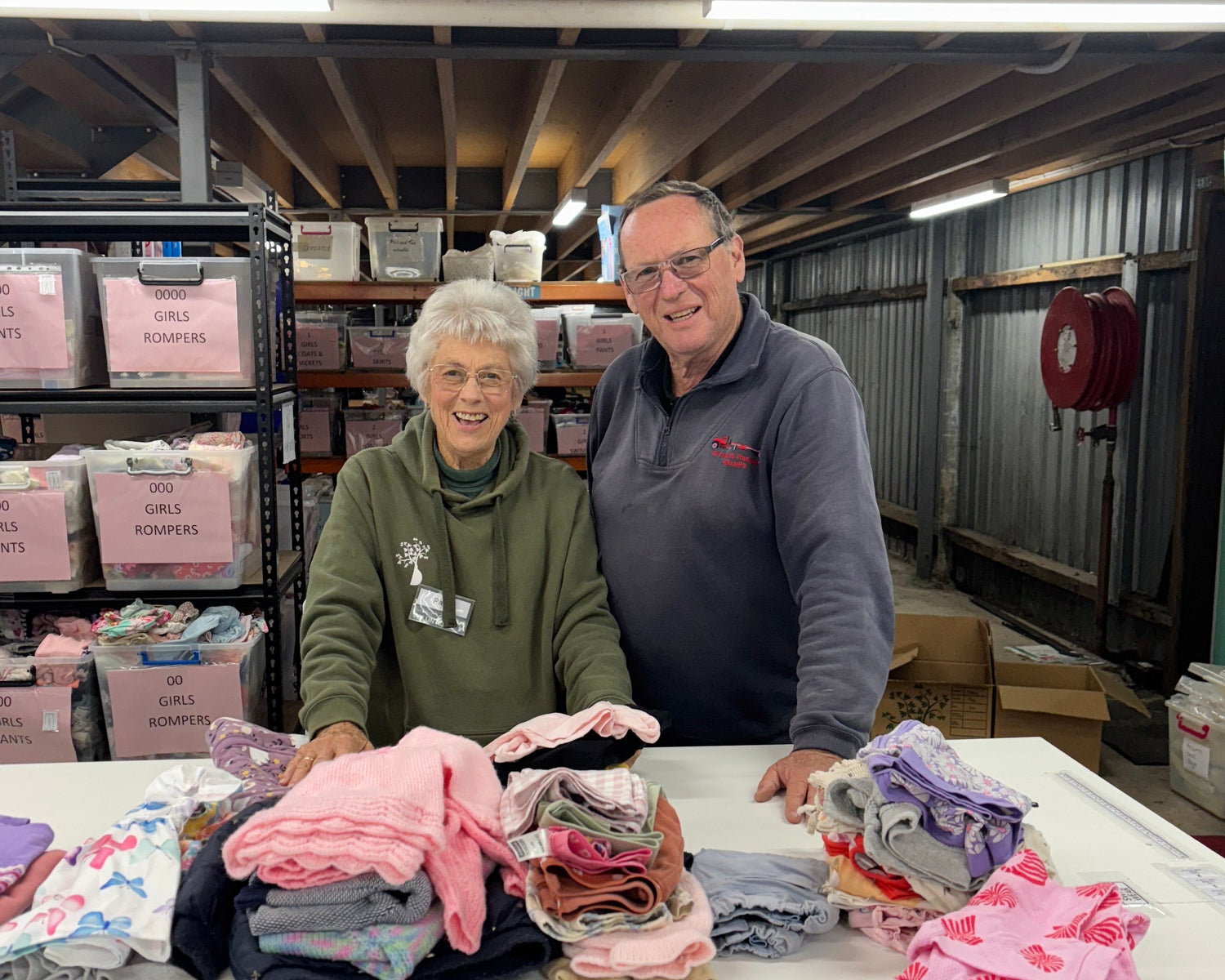 Two people standing in a store aisle with shelves and products.
